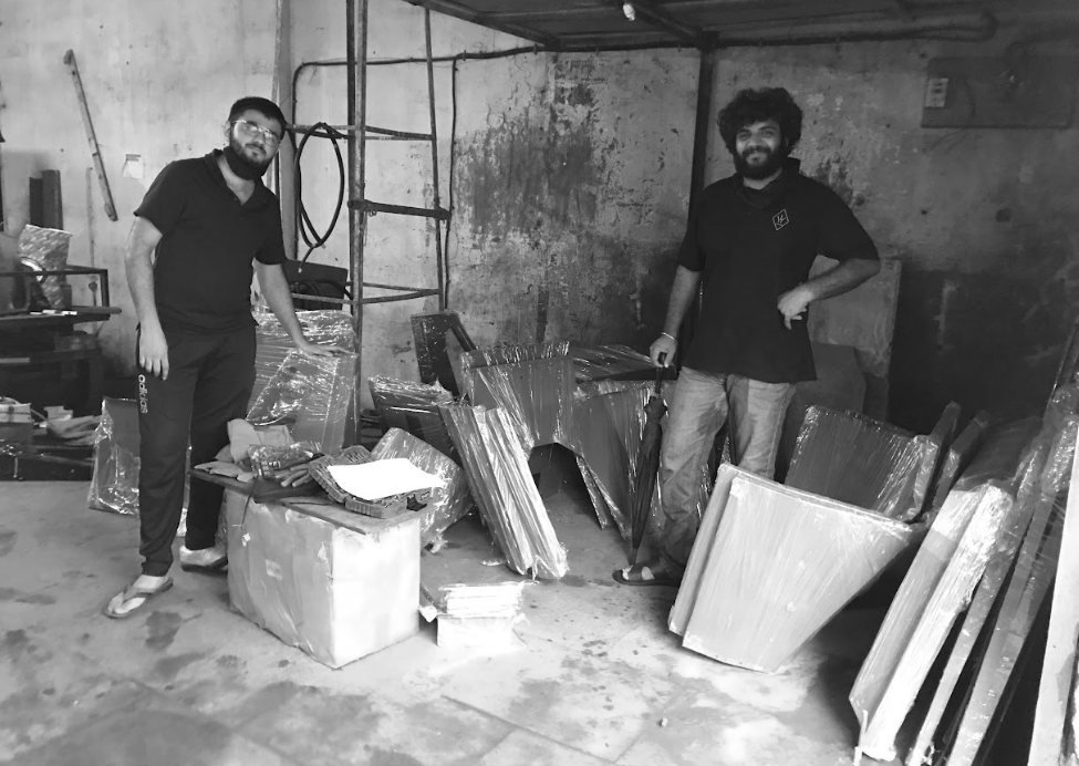 Black-and-white photo of the team with folded L5 panels laid out in the workshop