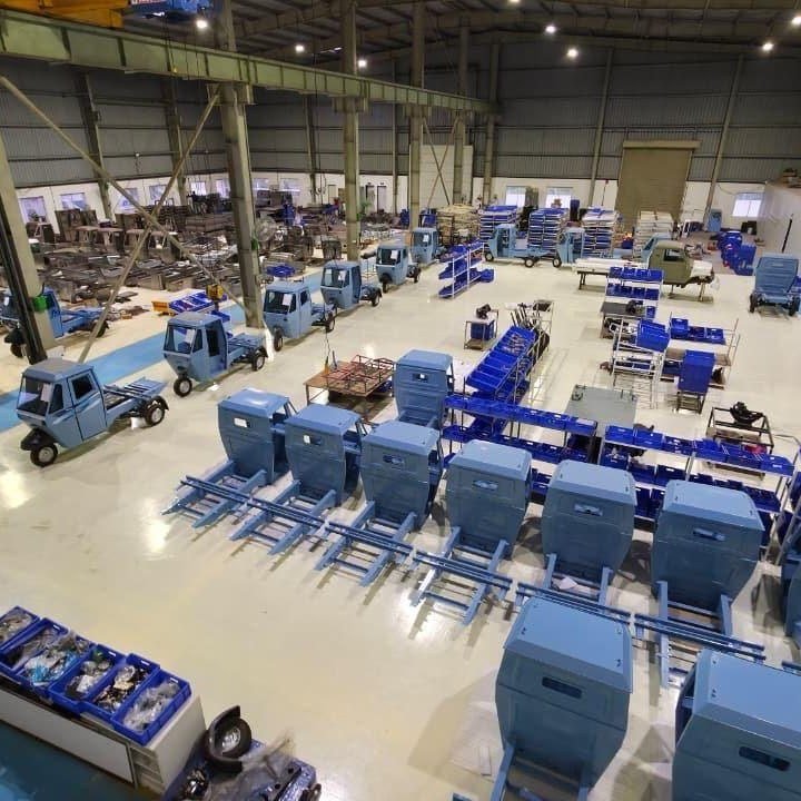 Aerial view of the Astro Motors factory floor with rows of blue three-wheelers