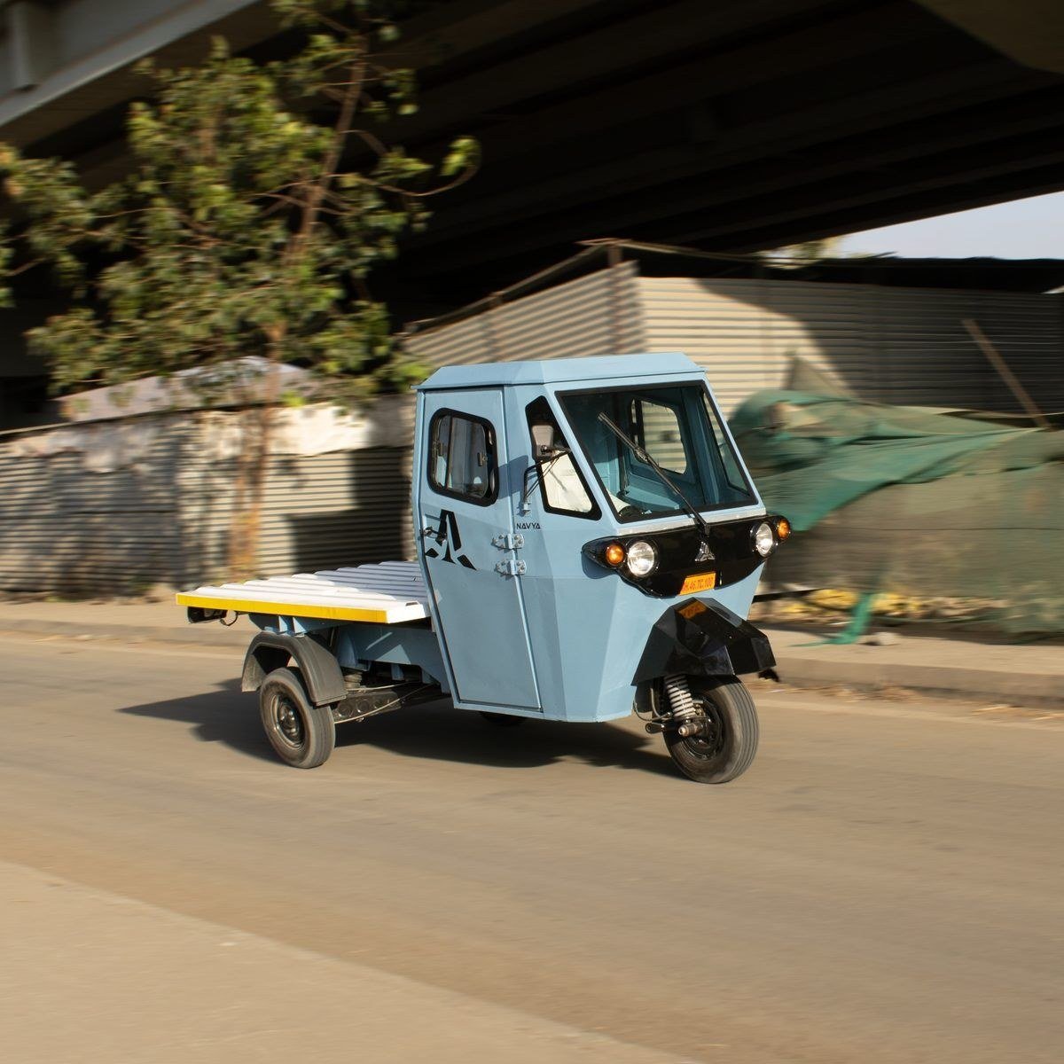 Front of the blue Navya with the finished headlight housing, on a flyover