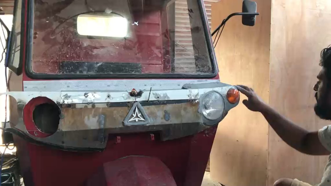 Sheet-metal headlight mock-up fitted across the red mule vehicle's front