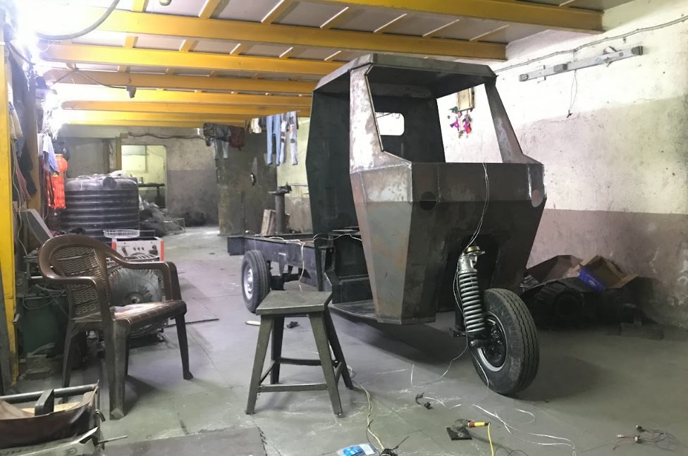 A cab body under construction in the workshop, hoisted over its chassis